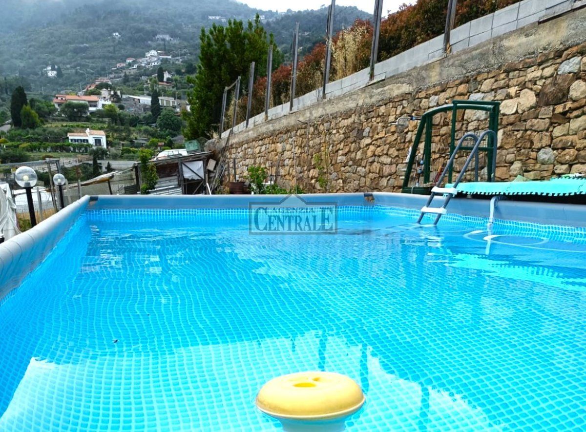 Aufstellpool mit Steinmauer und Bergblick