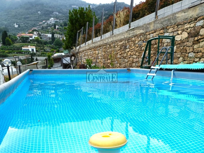 Aufstellpool mit Steinmauer und Bergblick
